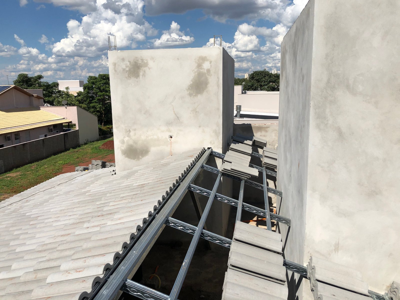 Estrutura metálica e início do assentamento das telhas em obra real